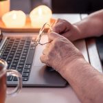 Emerytowana kobieta używa rąk laptopa z bliska