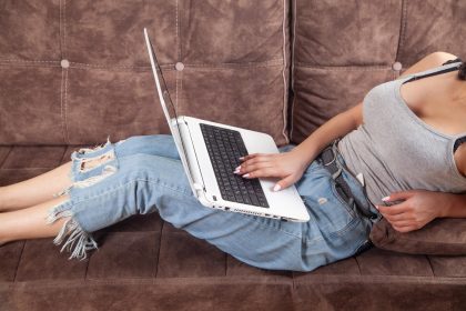 Kobieta korzystająca z białego laptopa w domu