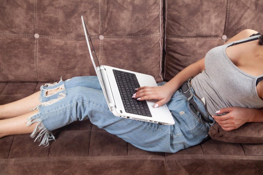Kobieta korzystająca z białego laptopa w domu