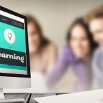 Ekran komputera przed uśmiechniętymi przyjaciółmi studentami korzystającymi z laptopa