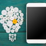 Koncepcja żarówka znak i telefon na biurku
