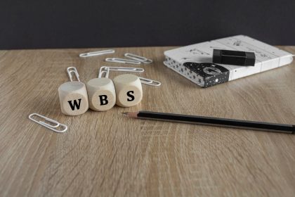 Akronim WBS Work Breakdown Struktura na drewnianych kostkach Piękny drewniany stół czarne tło Ołówek notatnik klipki do papieru Koncepcja biznesowa