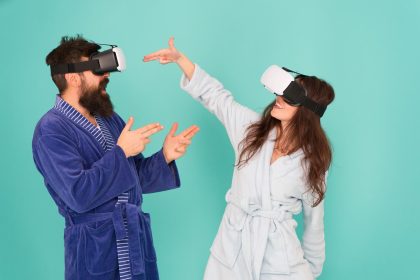 Ręce do góry Wstań i dostarczaj technologię VR i przyszłą komunikację VR Ekscytujące wrażenia Para w szlafroku nosi okulary VR Gry i rozrywka Mężczyzna i kobieta odkrywają VR w domu