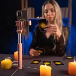 Astrologia online Wróżbiarz używa smartfona czyta karty tarota do przewidywań mówiąc klientom poprzez świadczenie usług za pośrednictwem telefonów komórkowych Koncepcja wróżbiarstwa ezoteryzmu