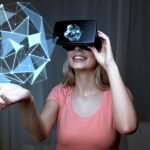 Technologia 3d, rzeczywistość wirtualna, rozrywka i koncepcja ludzi - szczęśliwa młoda kobieta z zestawem słuchawkowym rzeczywistości wirtualnej lub okularami 3d bawiącymi się projekcją kształtu low poly na czarnym tle