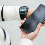 Kobieta łącząca się z telefonem komórkowym i smartwatchem