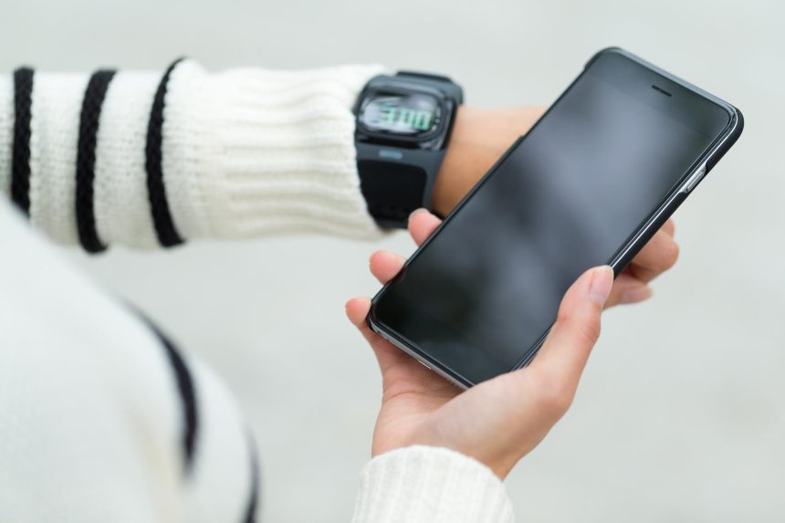 Kobieta łącząca się z telefonem komórkowym i smartwatchem