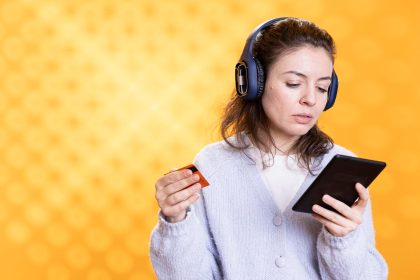 Kobieta trzymająca e-reader, słuchająca muzyki, kupująca książki.