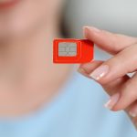 Kobieta trzymająca kartę SIM w domu z bliska