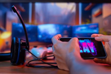 Ręce za pomocą smartfona z ekranową grą wideo i widocznym przyciskiem odtwarzania Koncepcja gier