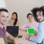 Grupa młodych biznesmenów omawiająca plan biznesowy w nowoczesnym budynku biurowym dla startupów