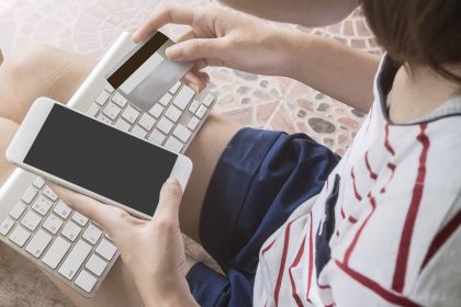 Trzymając się za ręce karty kredytowej i za pomocą laptopa, zakupy online