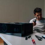 Young technician male examining small vacuum cleaner during cleaning computer parts ensuring optimal