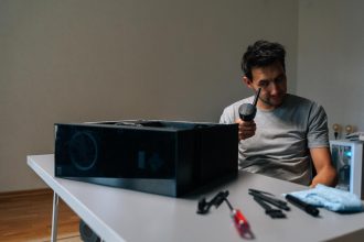Young technician male examining small vacuum cleaner during cleaning computer parts ensuring optimal