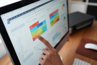Hand Interacting with a Digital Data Dashboard on a Computer Screen