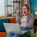 Myślliwa młoda kobieta freelancer miała pomysł i pisanie na laptopie netbook świętując zwycięstwo