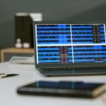 Laptop displaying financial data charts on office desk during workday
