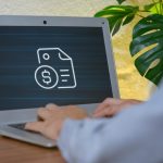 Person Typing on Laptop with Finance Document and Dollar Symbol Icon
