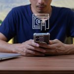 Man Engaged in Online Payment Process Using Smartphone and Laptop