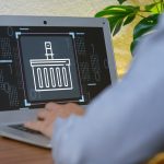 Digital Basket Icon on Laptop Screen with User in Modern Workspace