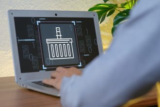 Digital Basket Icon on Laptop Screen with User in Modern Workspace