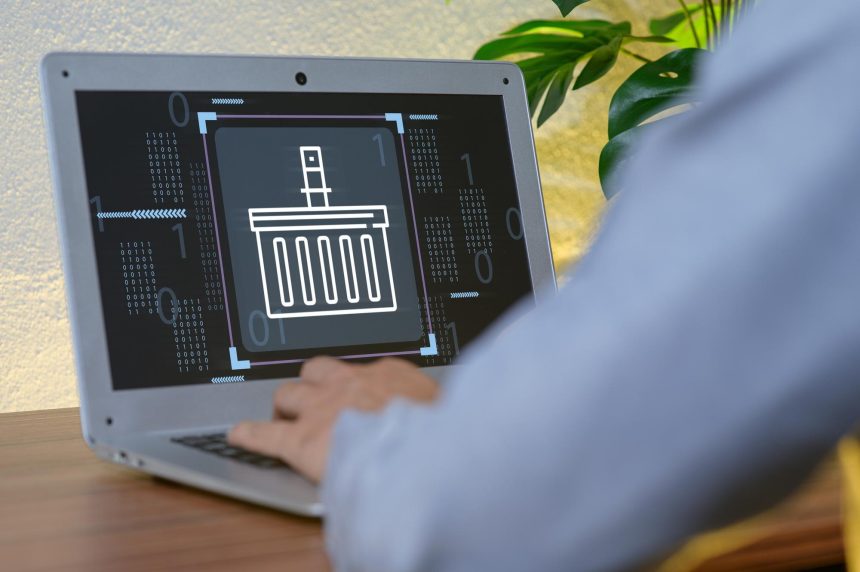 Digital Basket Icon on Laptop Screen with User in Modern Workspace