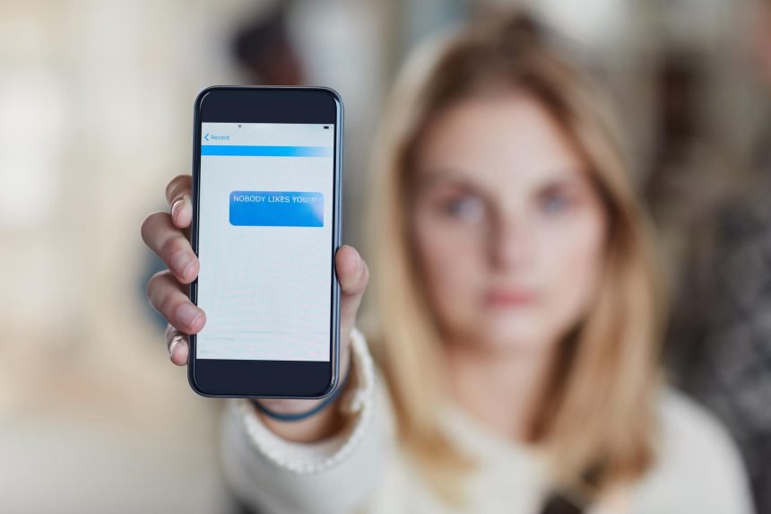 Hand phone screen and cyber bullying at university with social media stalker or notification at campus Person smartphone and rude chat with harassment mobile app and text message at college