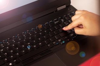 Kobieta klika przycisk Enter na laptopie