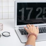 Żeńskie ręki używają laptop klawiaturę na bielu stole