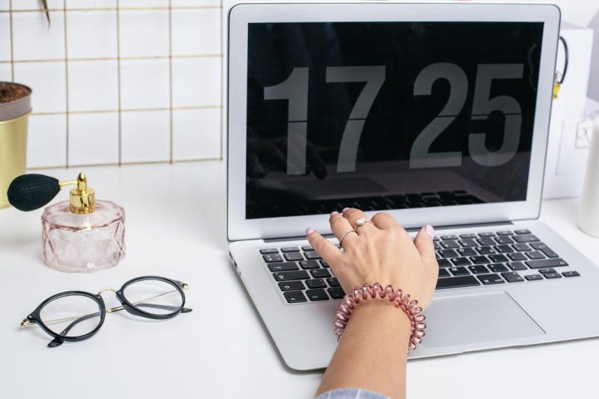 Żeńskie ręki używają laptop klawiaturę na bielu stole