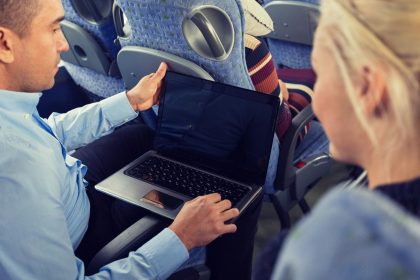transport, turystyka, wycieczka samochodowa, koncepcja technologii i ludzi - zbliżenie pary pasażerów z laptopem w autobusie podróżnym