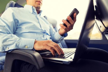 transport, turystyka, podróż służbowa i koncepcja ludzi - zbliżenie człowieka ze smartfonem i laptopem w autobusie podróżnym