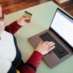 Top widok gruba kobieta z okularami robi zakup z strony internetowej e-commerce używając swojego laptopa