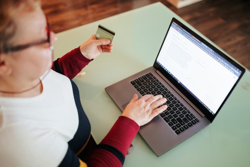 Top widok gruba kobieta z okularami robi zakup z strony internetowej e-commerce używając swojego laptopa