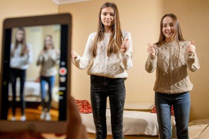 Dwie nastoletnie przyjaciółki tańczą i śpiewają za publikowanie w internetowych mediach społecznościowych i gadżetach