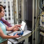 Technicy używający laptopa podczas analizy serwera