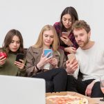 Grupa przyjaciół, patrząc na telefon