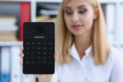 Uśmiechnięty portret bizneswoman trzyma kalkulator w ręku