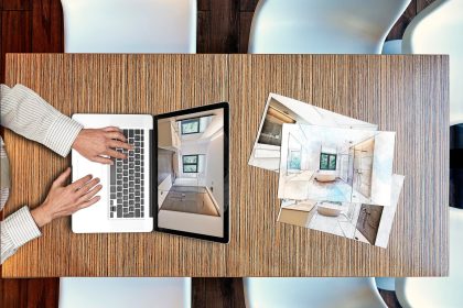 Przycięta ręka człowieka używającego laptopa na stole